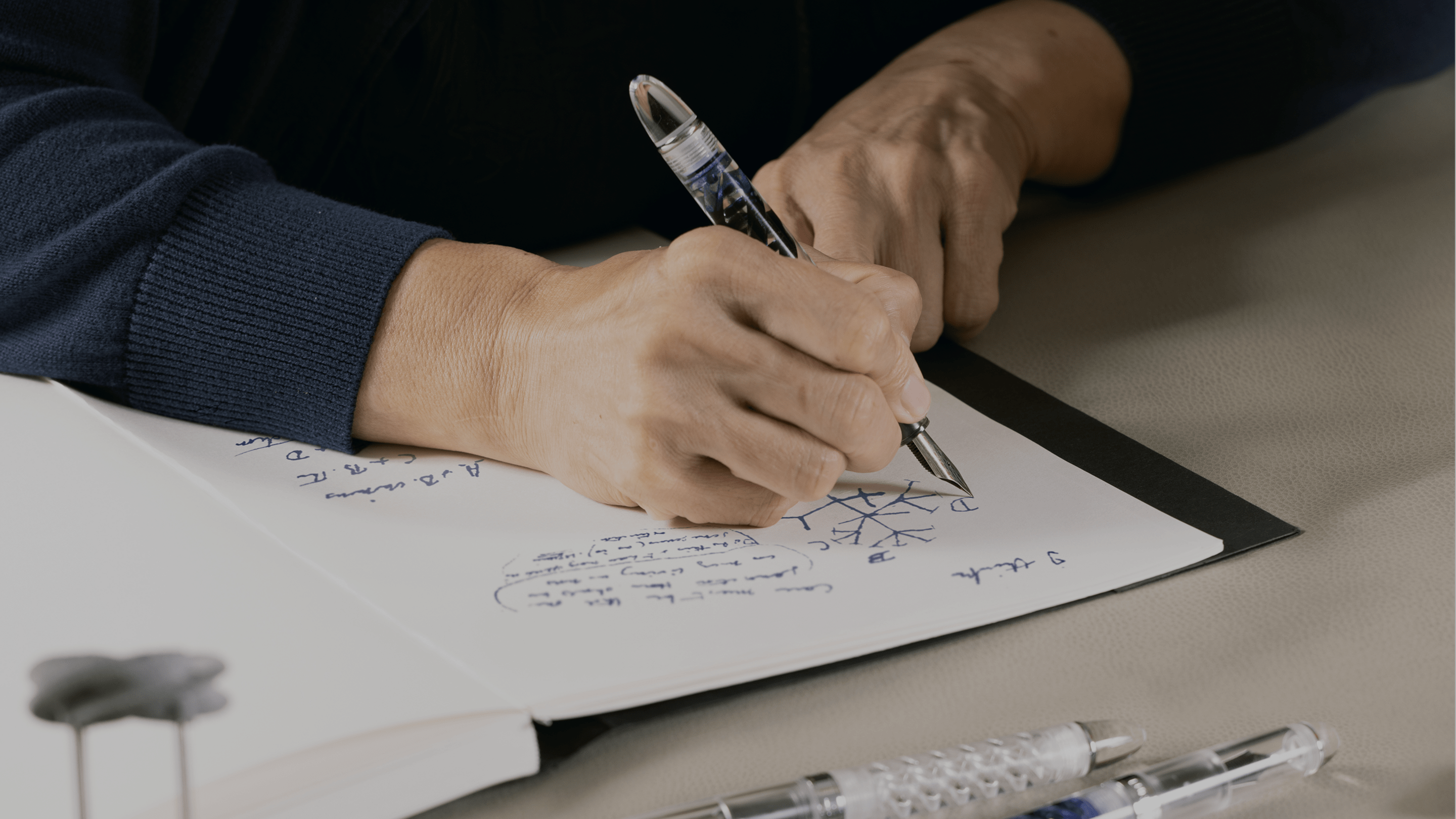 Person writing with DNA Lucent fountain pen, by Hex Pens.