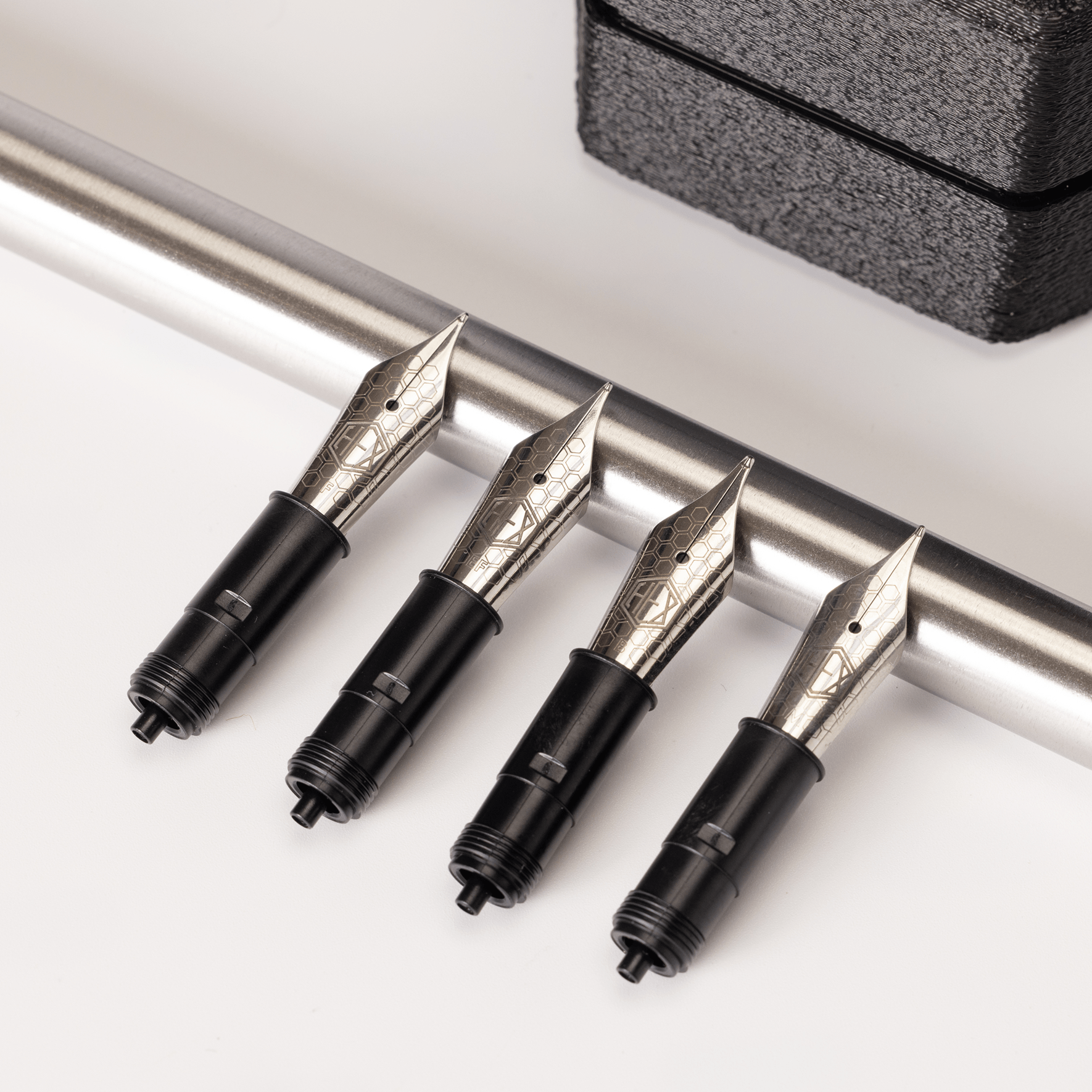 Hex Pens nib units placed on a steel rod, by Hex Pens.